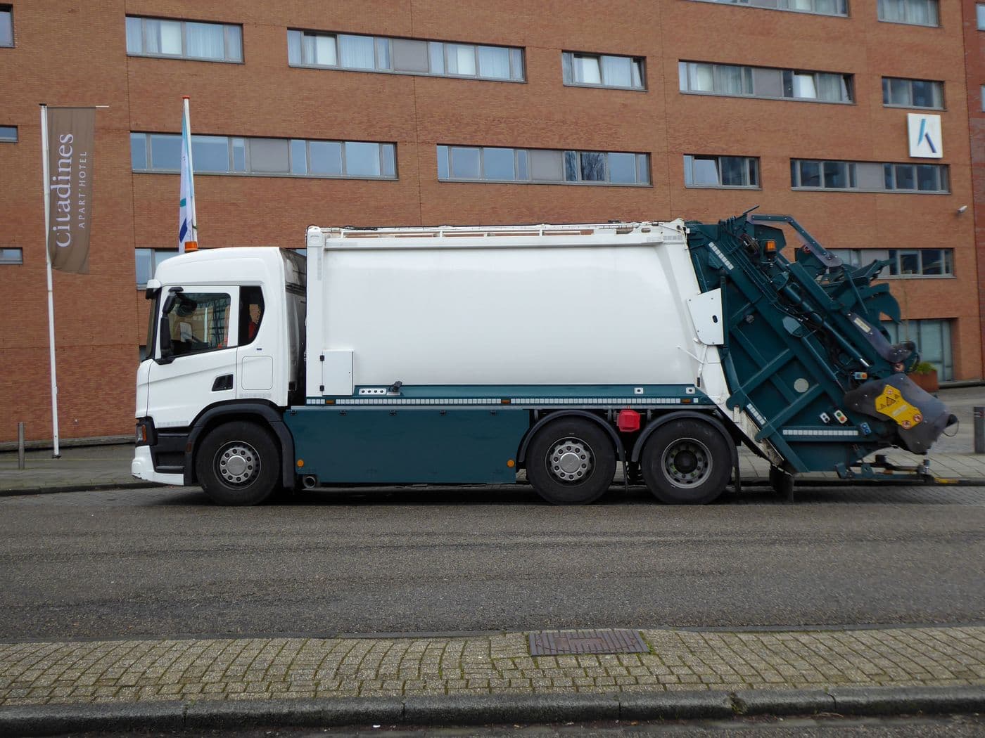 Kommunales Nutzfahrzeug am Straßenrand vor einem Verwaltungsgebäude