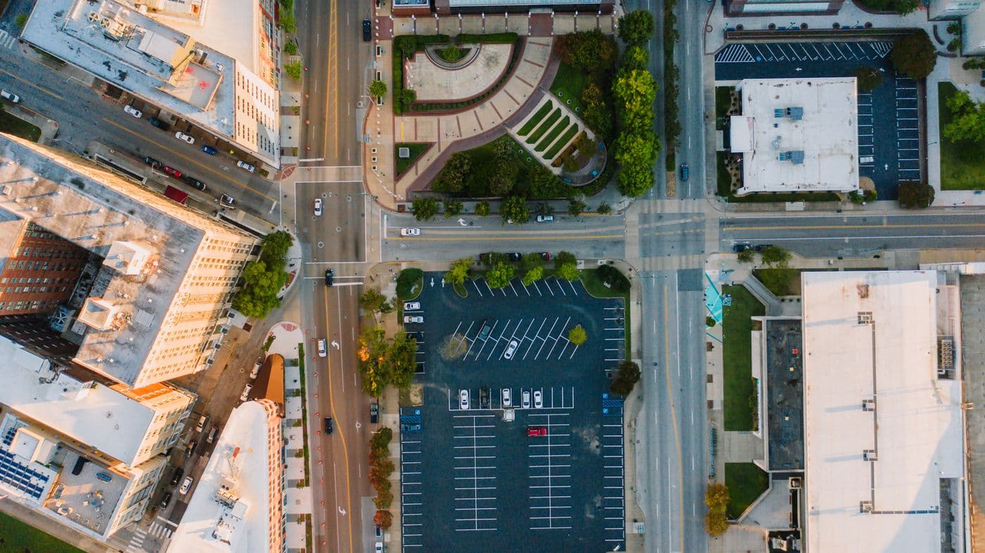 Parkplatz und Kreuzung aus der Luft im Stadtverkehr